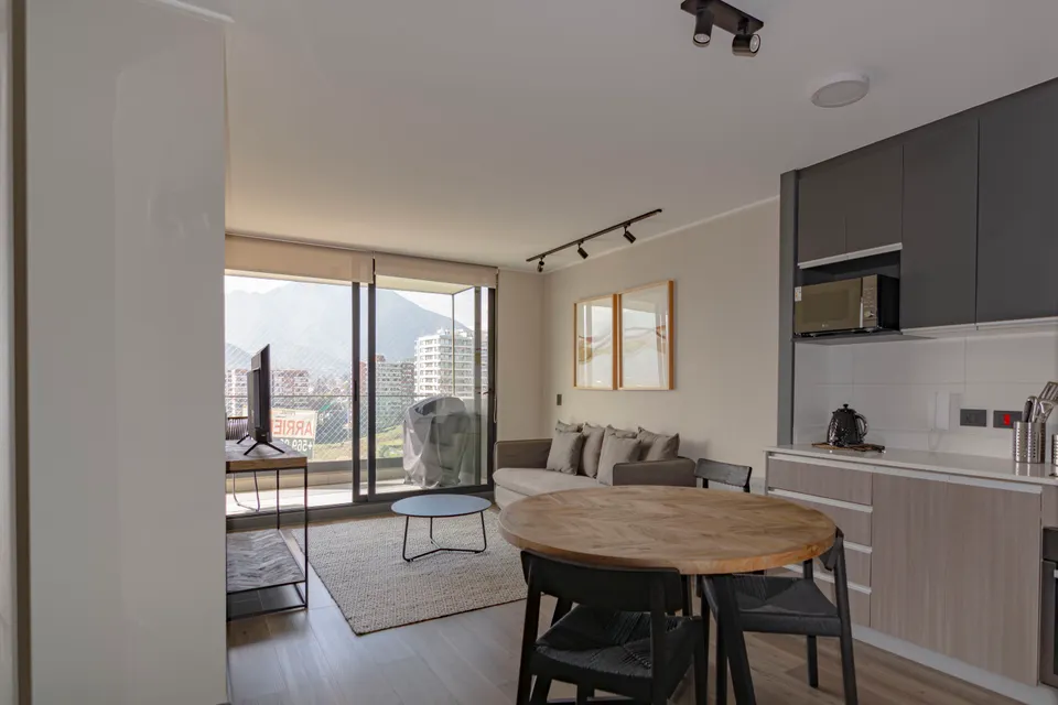 Bright living room opening onto a kitchen and balcony